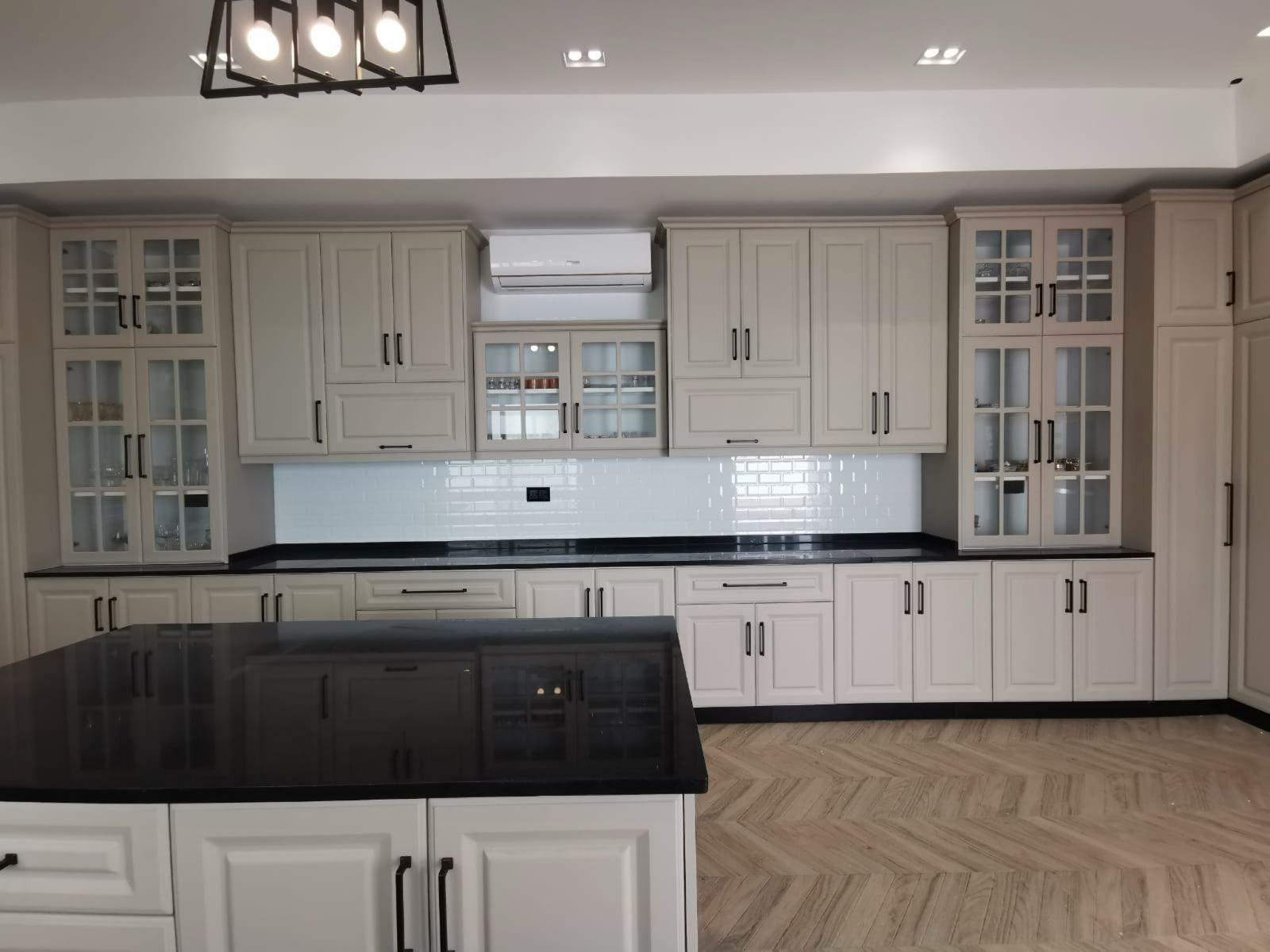 Full wall of kitchen cabinets with glass fronts — UAE villa